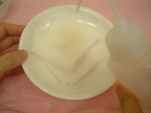 ガーゼを水で湿らせる様子